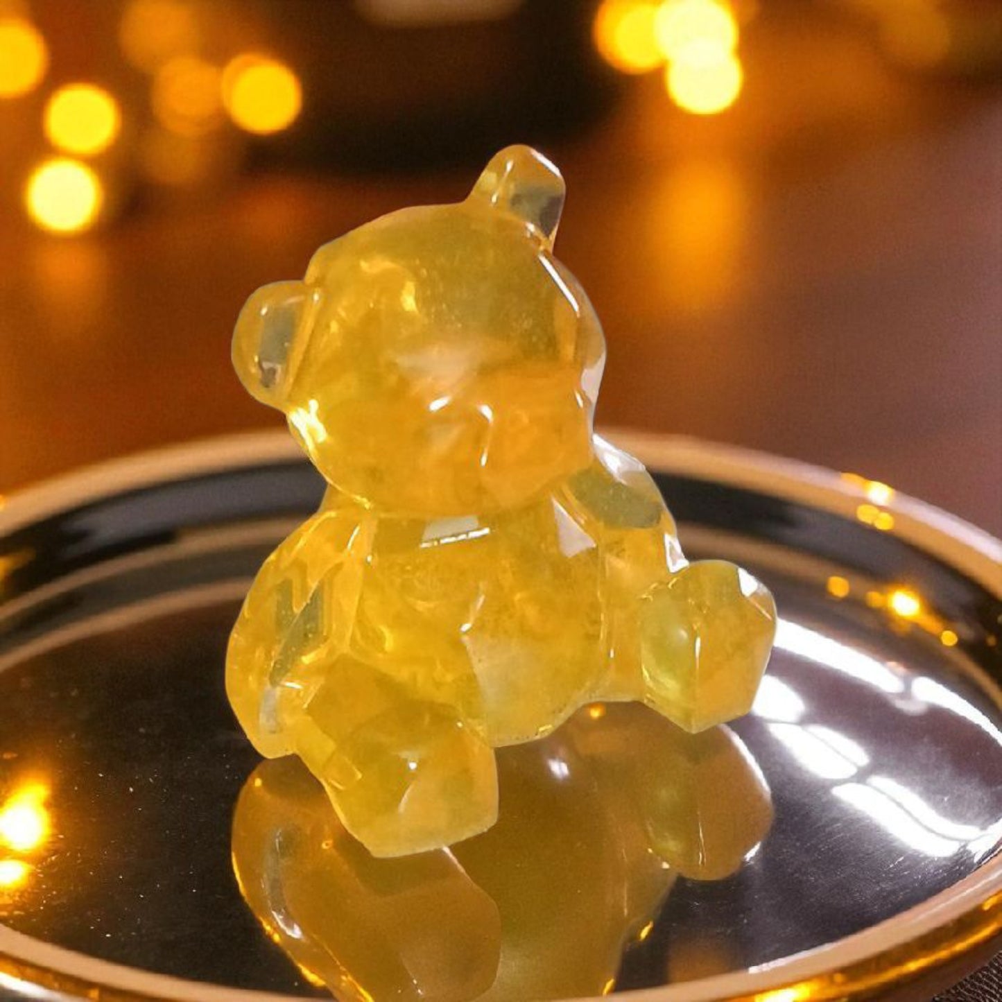 Gummy bear toy on a reflective surface with a blurred warm background