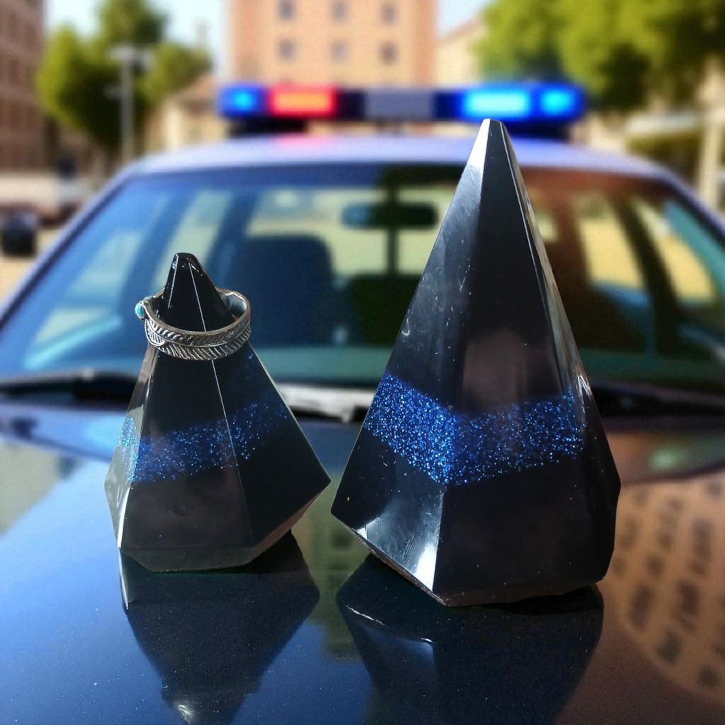 Two black and blue geometric objects on a police car with blurred background