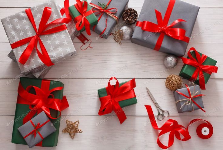 Gift boxes with red ribbons on a wooden surface
