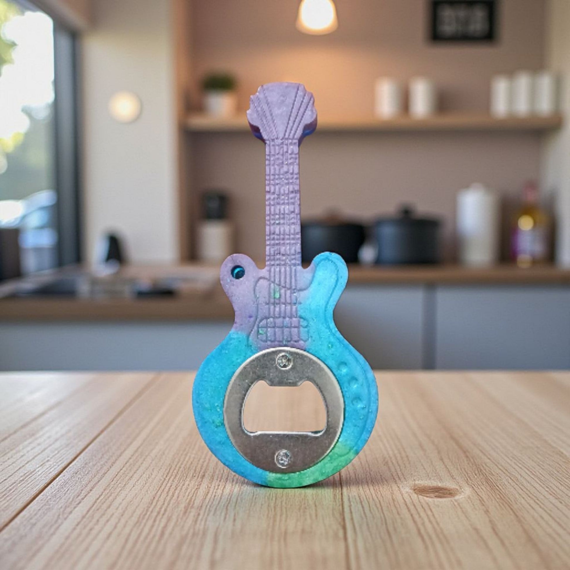Guitar-shaped bottle opener on a wooden surface with a kitchen background