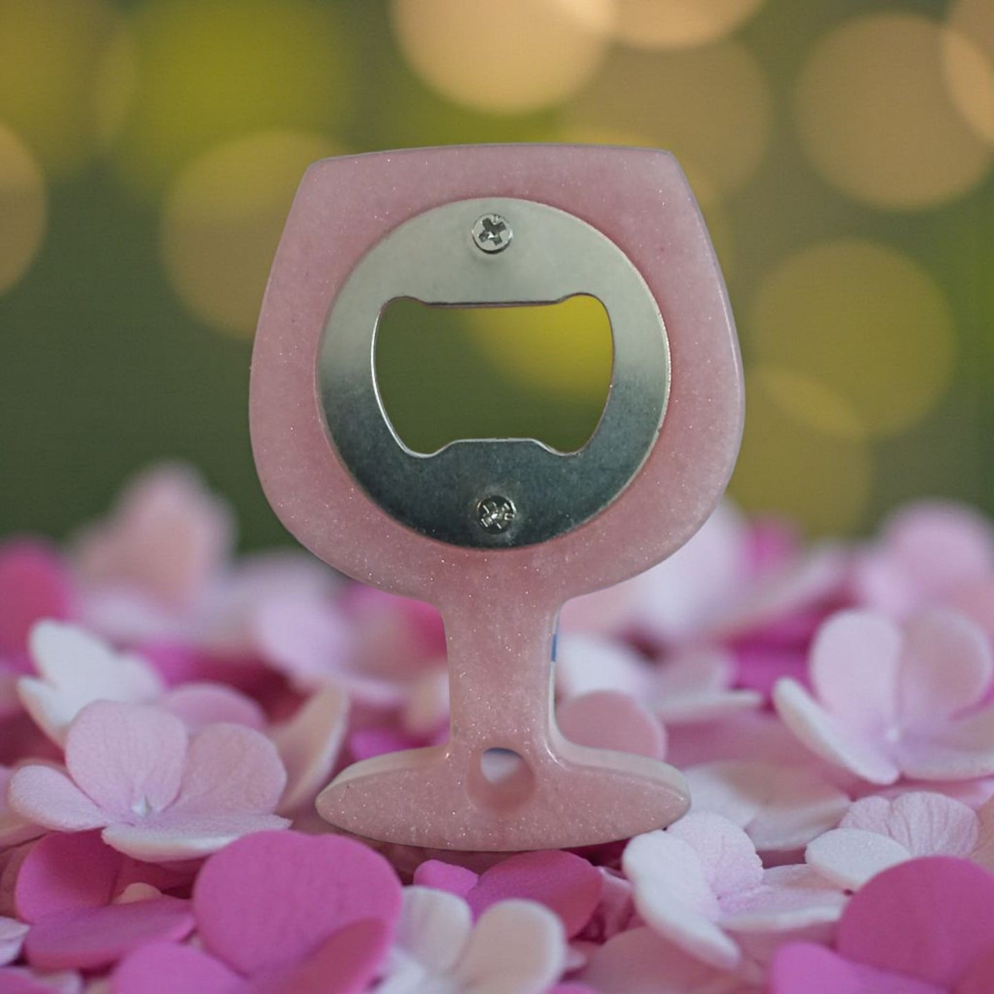 Pink bottle opener with a blurred floral background