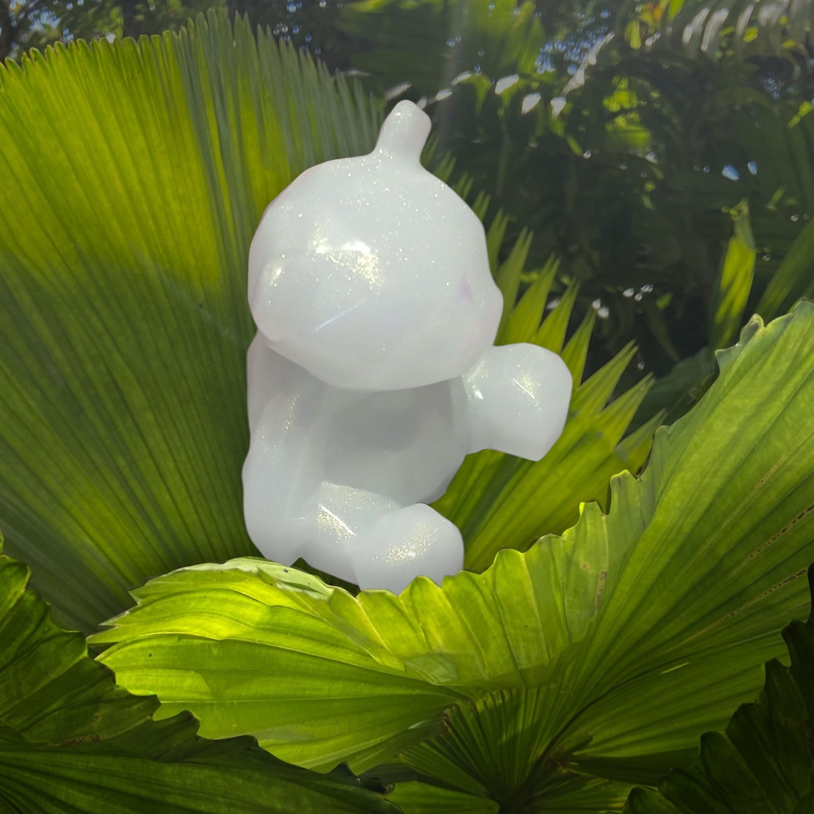 White sculpture of a child on green leaves