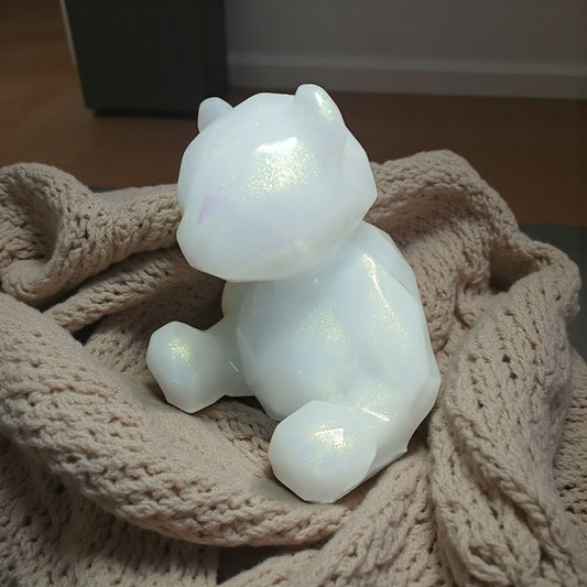 White ceramic cat figurine on a textured beige surface
