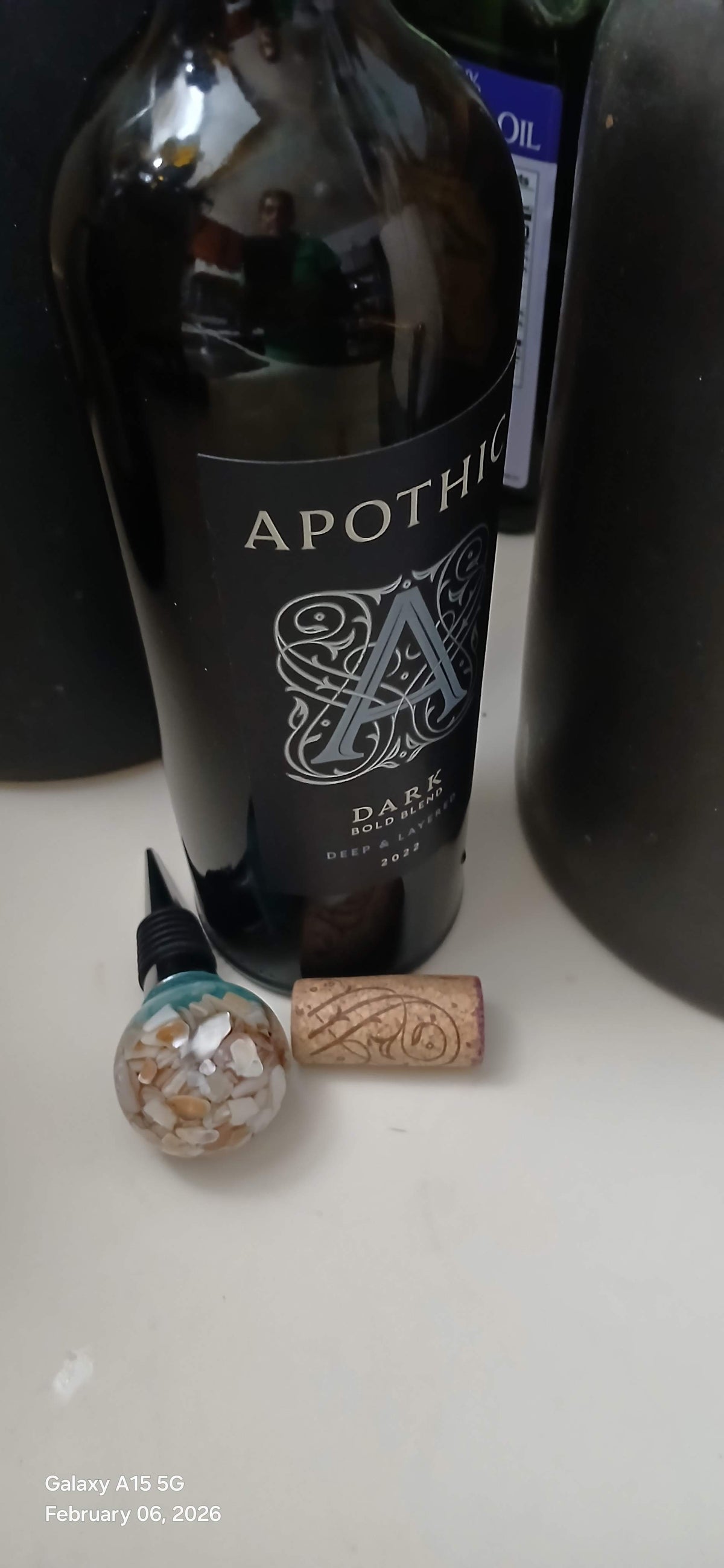 Wine bottle with cork and decorative stopper on a white surface
