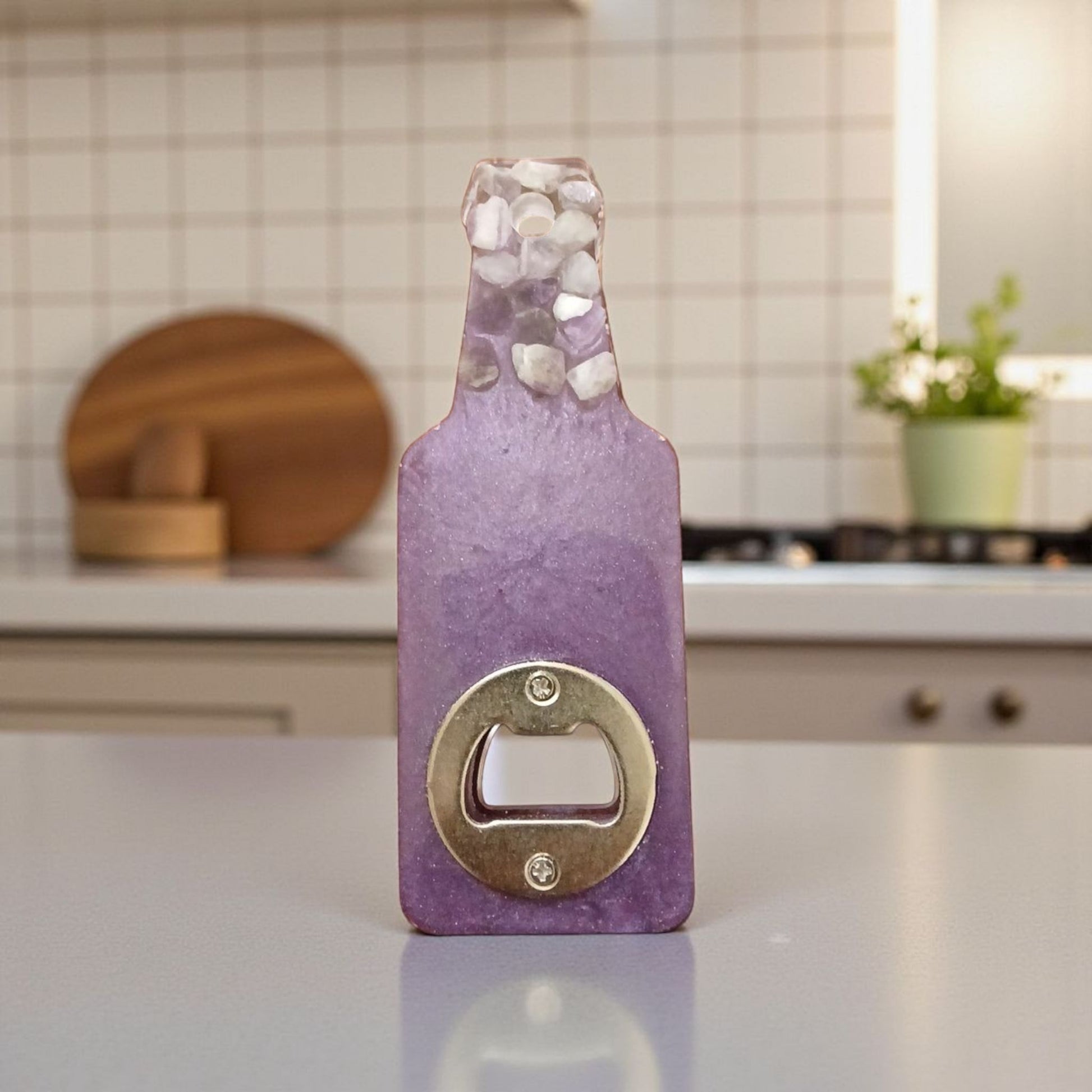 Purple bottle-shaped bottle opener on a kitchen counter