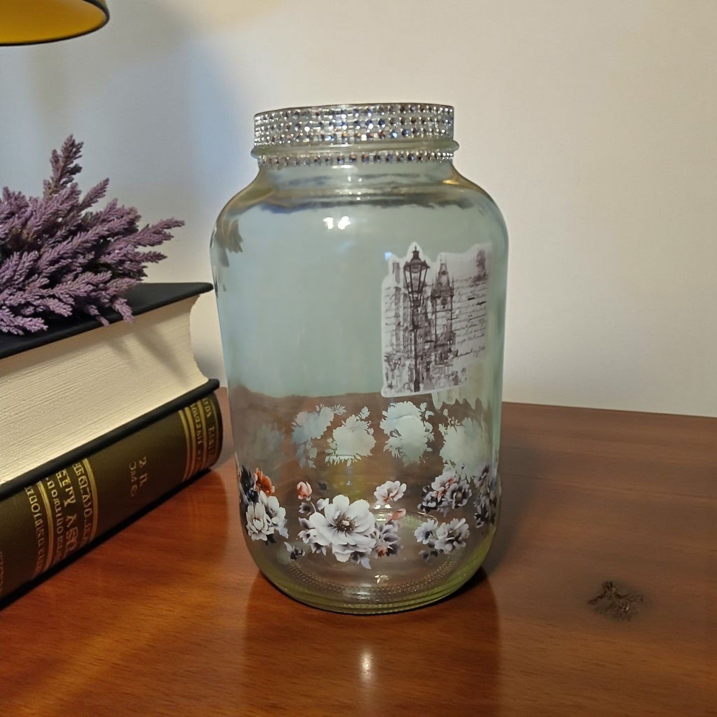 Decorative glass jar with floral design on a wooden surface