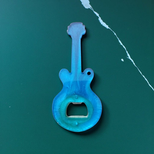 Blue guitar-shaped bottle opener on a green background
