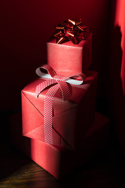 Two red gift boxes with ribbons on a dark background